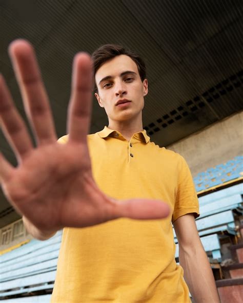 Homem posando ao ar livre de baixo ângulo Foto Grátis