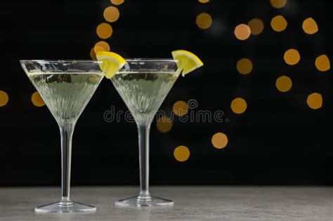 Martini Glasses Of Refreshing Cocktails With Lemon Slices On Light Grey