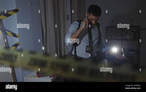 Hispanic Detective Investigates Indoor Crime Scene At Night Using