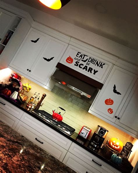 a kitchen with white cabinets and halloween decorations