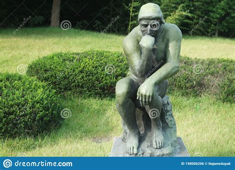 Green Statue Of Thinker Auguste Rodin Setting Naked On A Rock