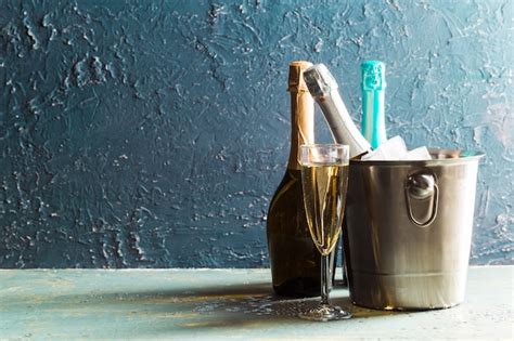 Premium Photo Champagne Bottle In Bucket With Ice And Glasses Of