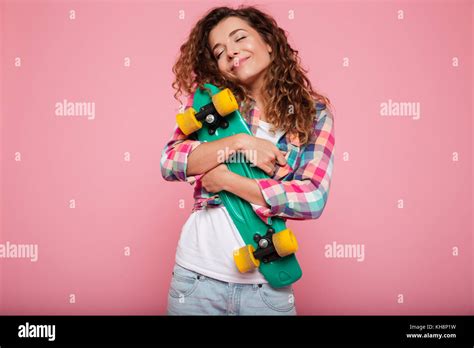 Smiling Pretty Brunette Lady In Shirt Hugging Her Green Skateboard And