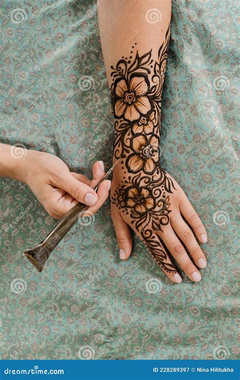 Artist Applying Floral Henna Tattoo on Women Hands, Design for Beauty ...