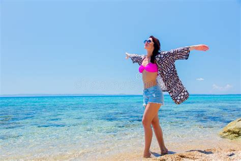 Muchacha De Youg En El Bikini Que Se Sienta En La Playa Foto De Archivo