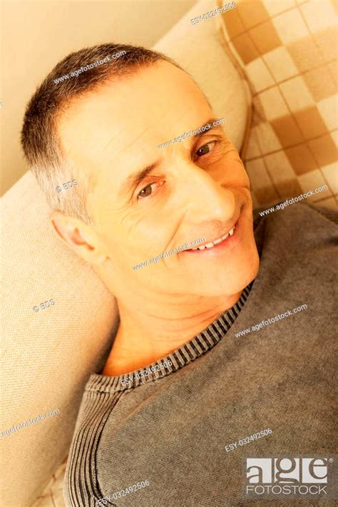 Smiling Mature Man Lying On A Sofa At Home Stock Photo Picture And