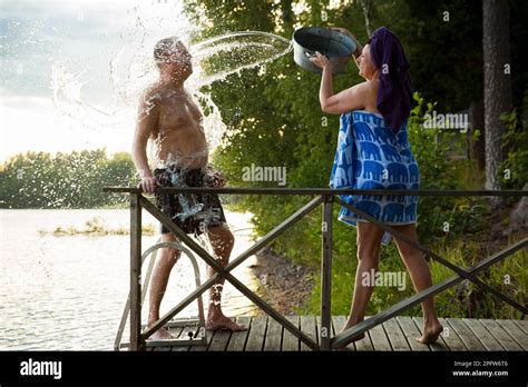 Aged Couple Having Fun After Finnish Sauna On Wooden Cottage Pier In A Lake Mature Woman