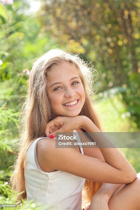 Portrait Of Pretty Teenage Girl Sitting Smiling Enjoying Nature Stock