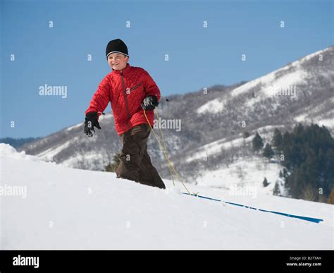Boy Pulling Sled In Snow Stock Photo Alamy