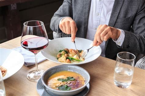 Premium Photo Man Is Eating In A Restaurant And Enjoying Delicious Food