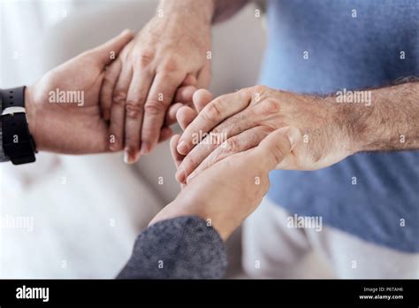 Male hands holding old male hands Stock Photo - Alamy