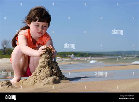 Kids On The Beach Young Girl Playing In The Sand To Make Sandcastles