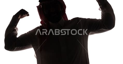 بورتريه ، صورة ظلية لرجل عربي خليجي سعودي ، يرفع يديه بكفين مقبوضتين ، القوة العضلية ، إستعراض