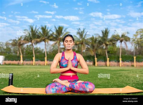 Fit Young Indian Woman Practicing Surya Namaskar Yoga Pose In Garden