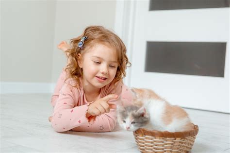 Una Ni A En Casa Jugando Con Un Gatito En El Suelo En Una Canasta