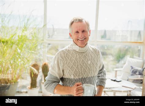 Portrait Smiling Senior Man Drinking Coffee In Beach House Sunny Sun