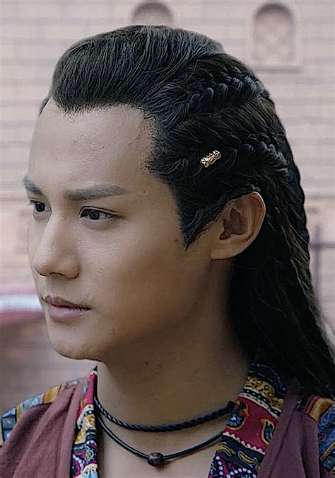 A Man With Long Black Hair And Braids On His Head