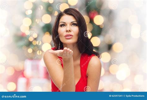 Mulher Que Envia O Beijo Do Sopro Sobre Luzes De Natal Imagem De Stock