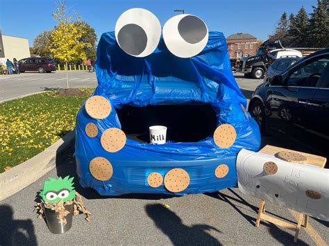 An Inflatable Blue Car With Googly Eyes On It And A Planter Next To It