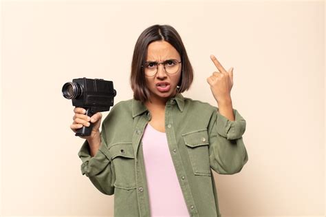 Mujer latina joven que parece sorprendida con la boca abierta conmocionada dándose cuenta de