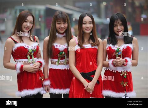 Young Chinese Girls Dressed In Christmas Costumes Pose As They Seek Hugs From Pedestrians On A