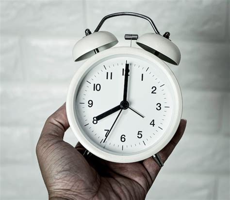 Premium Photo Close Up Of Hand Holding Alarm Clock