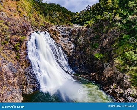 A Waterfall Flowing Over A Lush Green Hillside Next To A Forest Wujal