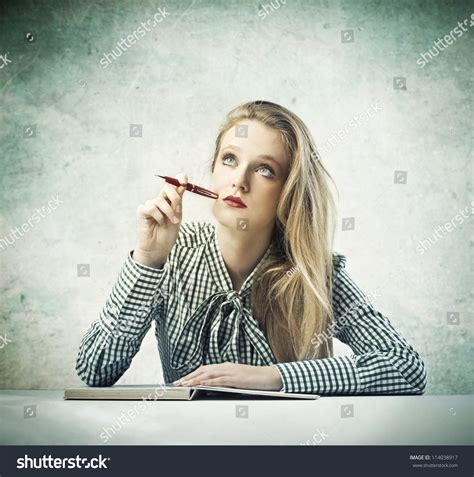 Beautiful Blonde Girl Thinking While Writing Stock Photo 114038917