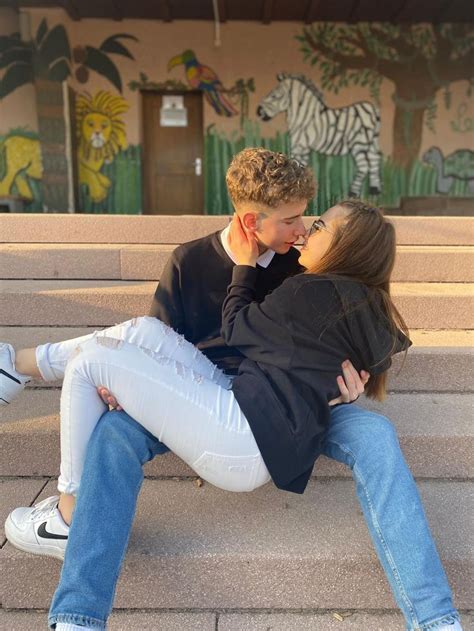 A Man And Woman Are Sitting On The Steps Hugging Each Other While They