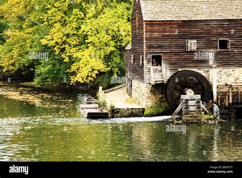 A Restored Grist Mill With A Water Wheel Standing A River Bank Stock