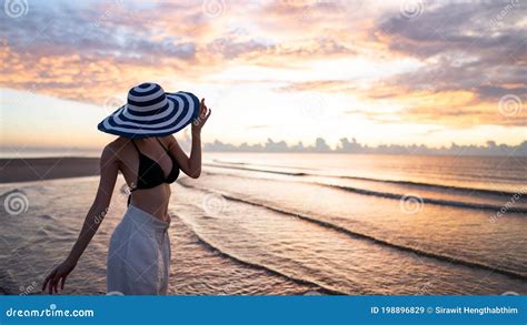 Femme Au Chapeau De Port De Bikini Supérieur Et De Longue Culotte Blanche Sur La Plage Avec Un