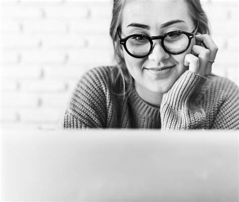 Mujer joven alegre que usa la computadora portátil Foto Gratis