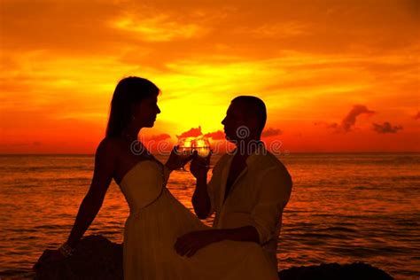 Romantic Couple At Tropical Beach With Sunset In The Background Stock