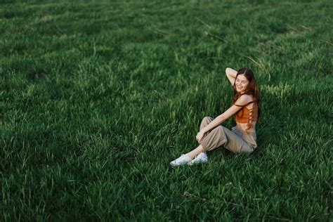 Premium Photo High Angle View Of Young Woman Sitting On Grassy Field