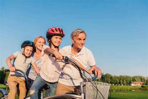 Grandparents Helping Children Ride Bicycle Stock Image Image Of Help