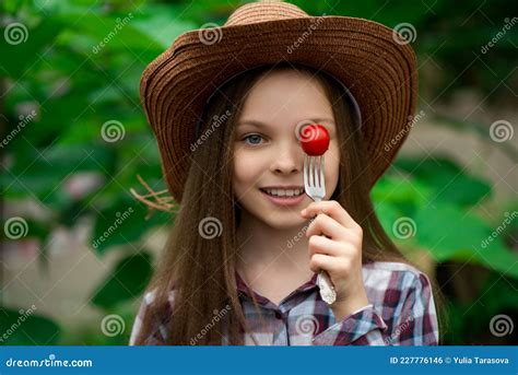 Mignonne Petite Fille Souriante Avec Tomate Cerise Sur Fond Vert Photo