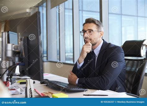 Businessman Sitting At Desk In Office Using Computer Stock Image