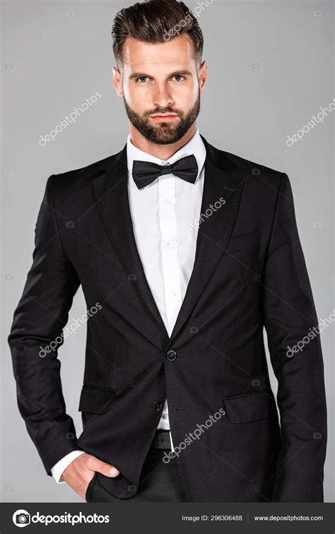 Man Wearing A Black Suit And Bow Tie On Gray Background Stock Photo By