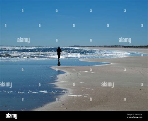 Lone Woman Walking On A Beach In Winter Atlantic Ocean In Anastasia