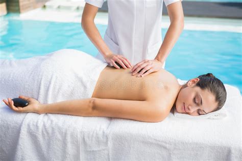 Happy Brunette Getting A Hot Stone Massage Poolside Stock Photo Image