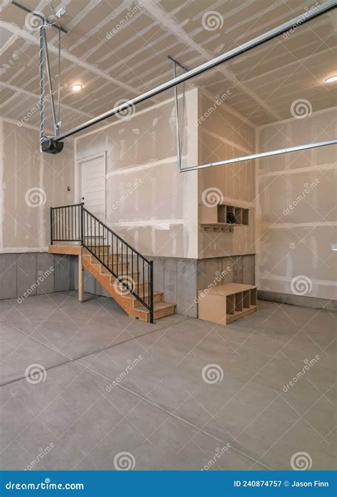 Vertical Interior Of An Unfinished Garage With Staircase Leading To The