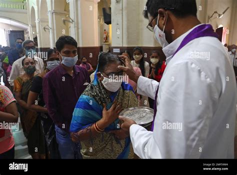 A Catholic Priest Marks The Forehead Of A Devotee With The Symbol Of A