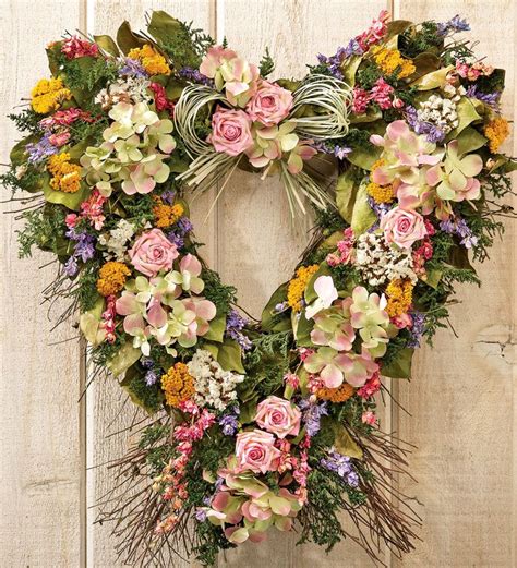 A Floral Wreath Hanging On The Side Of A Wooden Door With Flowers And