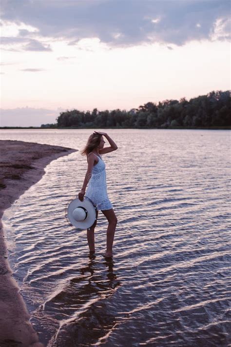 A Young Woman Looks At The Sunset A Beautiful Happy Slender Blonde Is