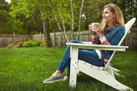 Take Some Time To Unwind A Mature Woman Sitting In Her Backyard Stock