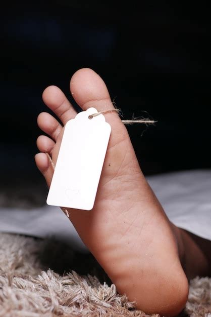 Le Corps Du Mort Avec Une étiquette Vierge Sur Les Pieds Sous Un Tissu