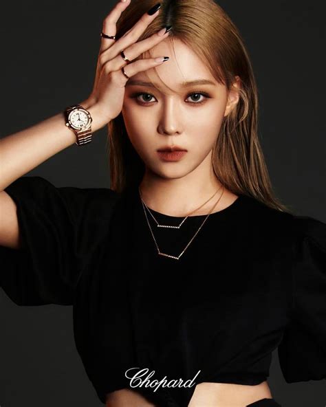 The Girl Is Posing With Her Hands On Her Head And Wearing A Black Top