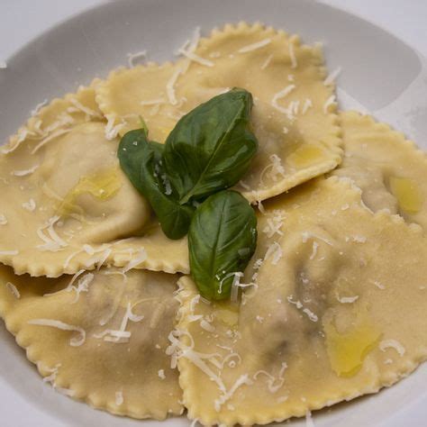 Ravioli With Cheese And Spinach Leaves In A White Bowl