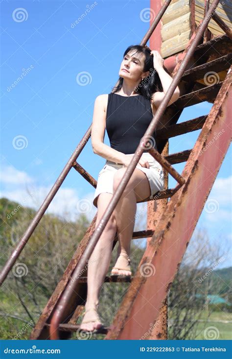 45 Years Old Russian Woman Sitting On Stairs And Looking Away Stock