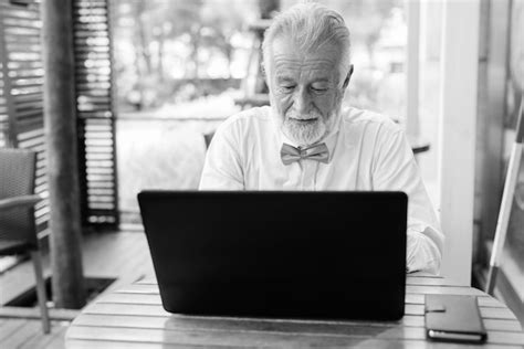 Premium Photo Man Using Mobile Phone While Sitting On Table